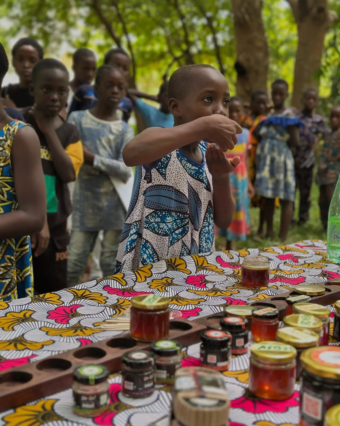 Un enfant goûte le miel à la table de dégustation, au Palais de Lomé