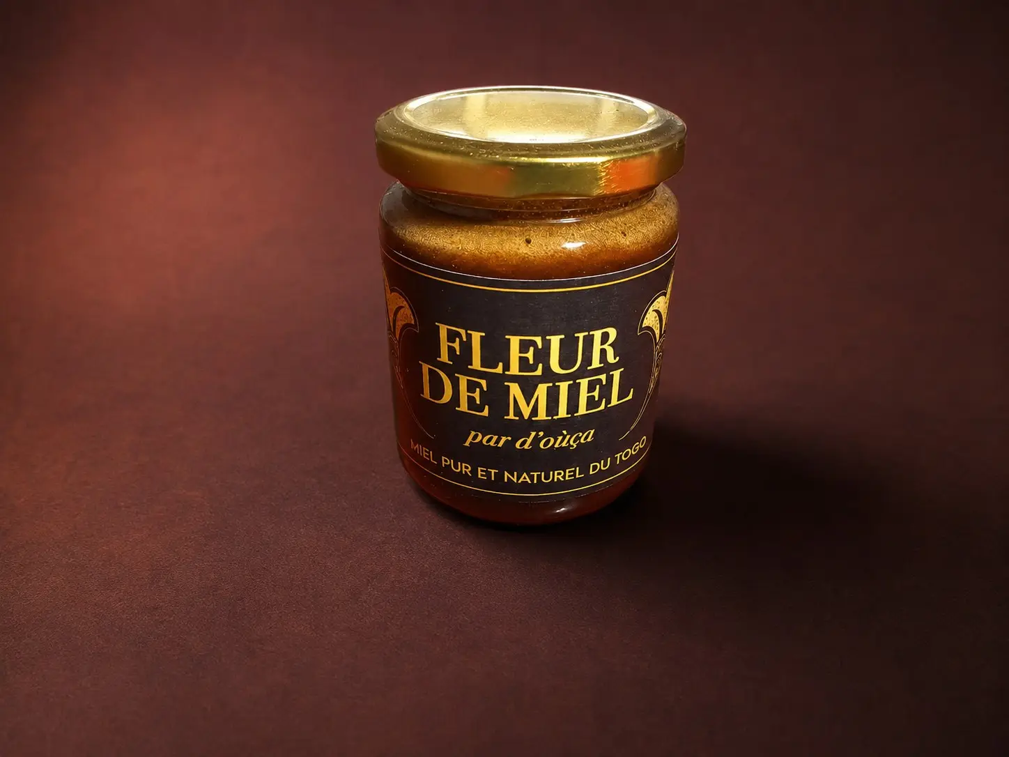 A jar of D'oùça? Fleur de miel, gold label on a deep red background